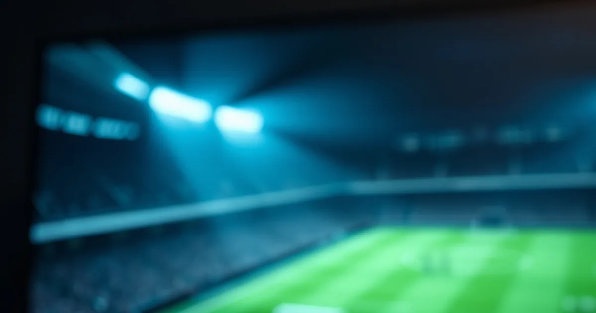 Een afstandsbediening en streaming-stick voor een televisie met een wazig voetbalveld en stadionlichten op de achtergrond